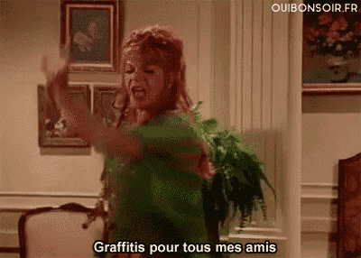 a woman is dancing in a living room with her arms in the air and says `` graffitis pour tous mes amis '' .