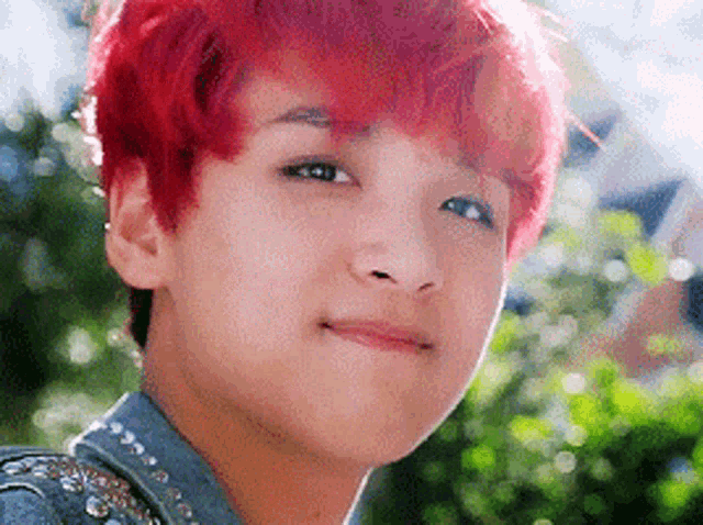 a close up of a person 's face with red hair and a denim jacket .