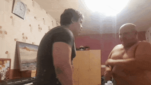 two men are standing next to each other in a room with a clock on the wall that shows the time as 4:20