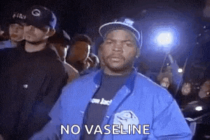 ice cube is wearing a blue jacket and a black shirt and is standing in front of a crowd .
