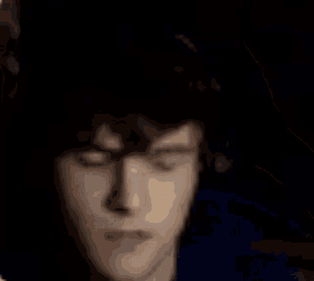 a blurry picture of a person holding their head .
