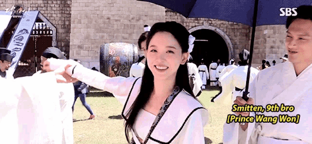 a man holding an umbrella next to a woman with the words " smitten 9th bro prince wang won " on the bottom