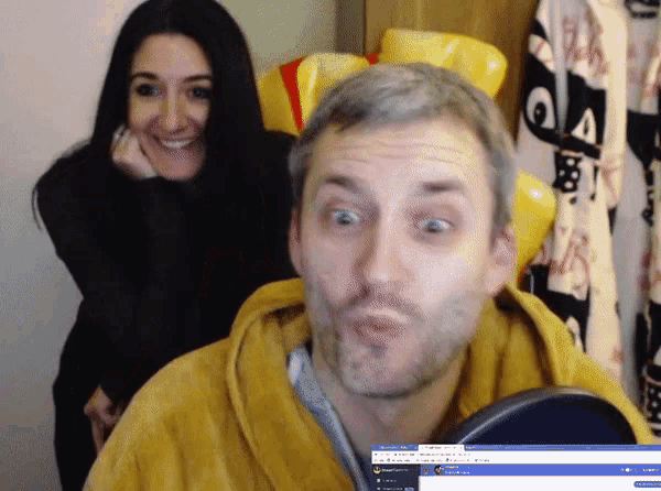 a man and a woman are standing in front of a screen that says ' a ' on it