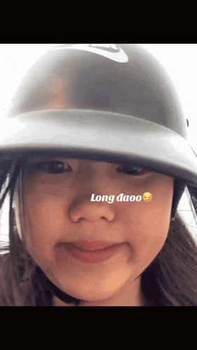 a girl wearing a helmet has the word long on her nose