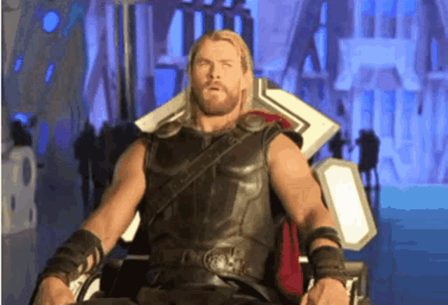 thor is sitting on a throne and looking at the camera