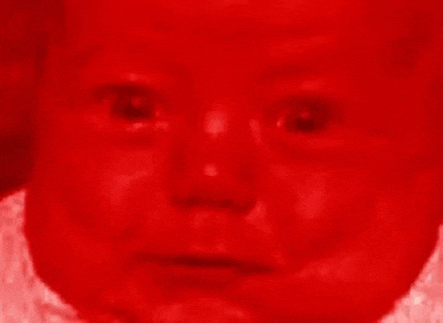 a close up of a baby 's face covered in red .