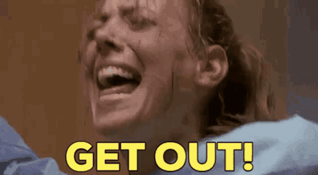 a woman in a hospital gown is screaming with her mouth open and the words `` get out '' written on her face .