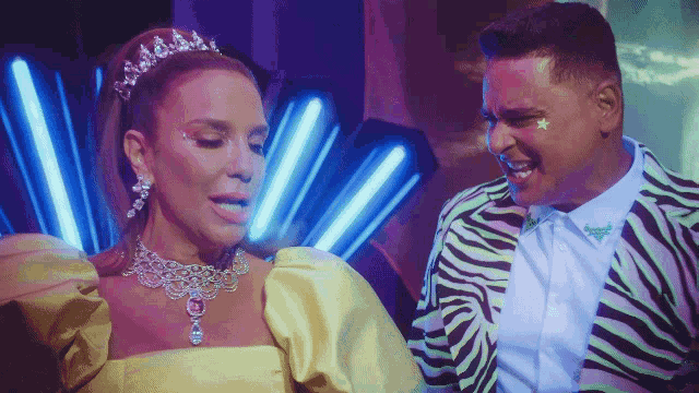 a man in a zebra print jacket stands next to a woman in a tiara