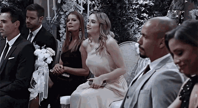 a group of people sitting in chairs at a wedding ceremony