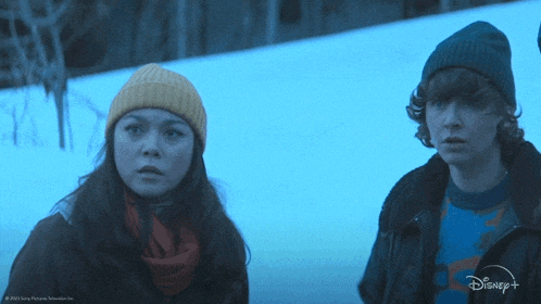 a man and a woman are standing in the snow with disney + written on the bottom