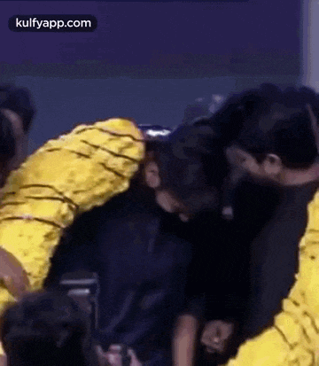 a group of people are hugging each other in a circle .
