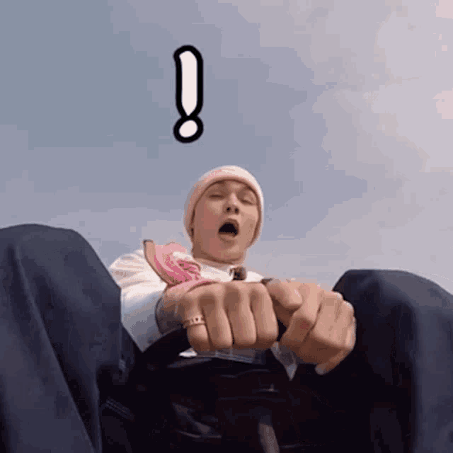 a man wearing a pink hat and a ring with an exclamation point above him