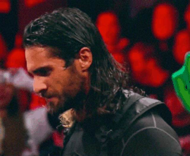 a man with long hair and a beard looks down at something