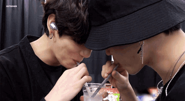 two men are drinking from a cup with straws and the words outnower are on the bottom of the image