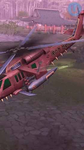 a red helicopter is flying through a field with a red laser beam coming out of it