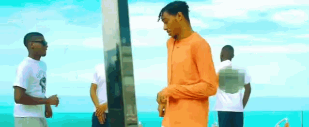 a group of young men are standing next to each other on the beach .