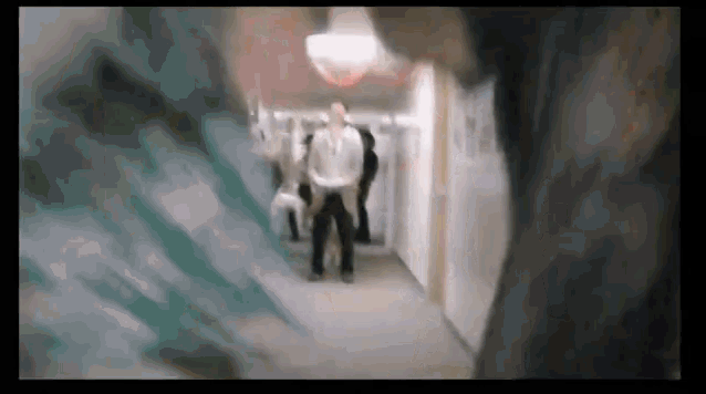 a blurry picture of people walking down a hallway