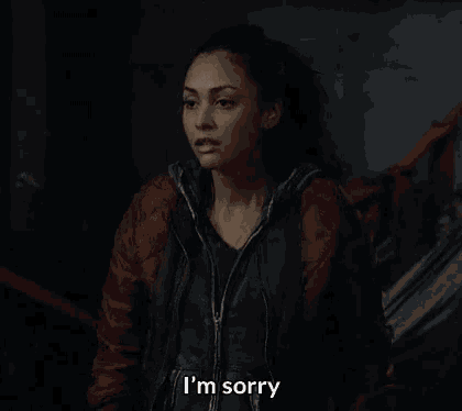 a woman in a red jacket is saying i 'm sorry .
