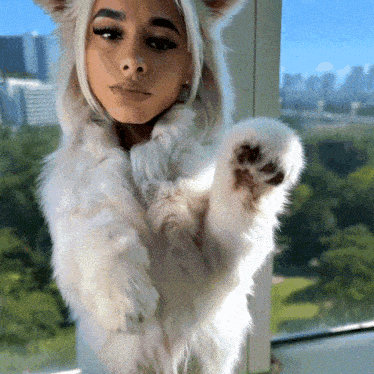 a woman is wearing a white fur coat with ears on it