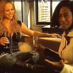two women are sitting at a table holding glasses of wine and a tablet .