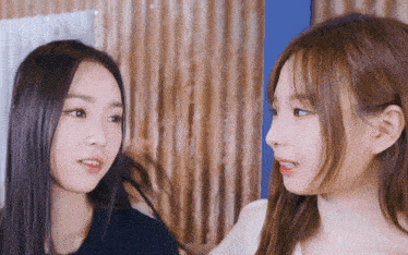 two girls are looking at each other and one is holding her hair