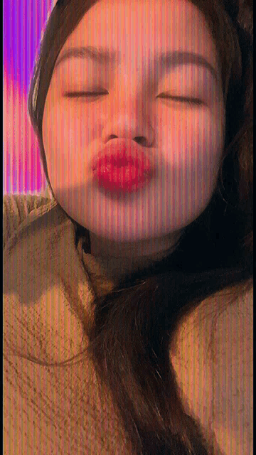 a woman is making a funny face with her eyes closed and red lips