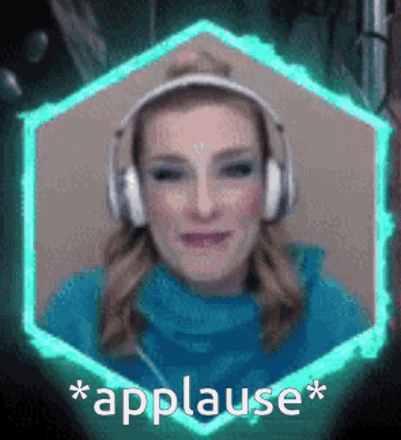 a woman wearing headphones and a blue sweater applauds .