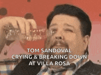 a man with a beard is drinking water from a bottle and crying .