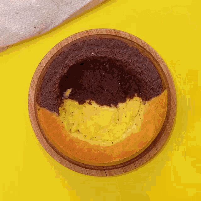 a brown and yellow cake is being poured with chocolate sauce .