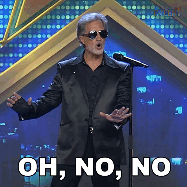 a man in a suit and sunglasses singing into a microphone with the words oh no no on the bottom