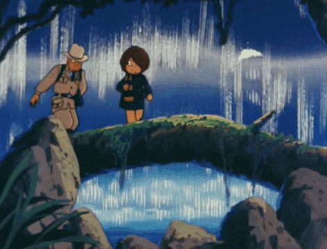 a man and a girl are standing on a rock near a waterfall