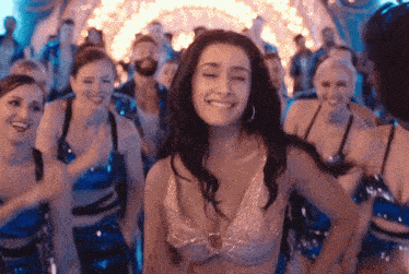 a woman is dancing in front of a crowd of people in a club .