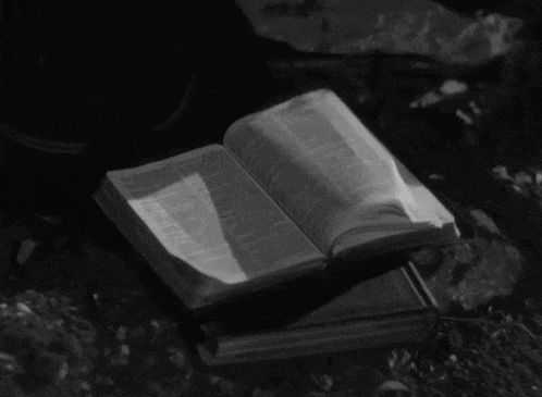 a black and white photo of an open book with a page that says ' bible ' on it