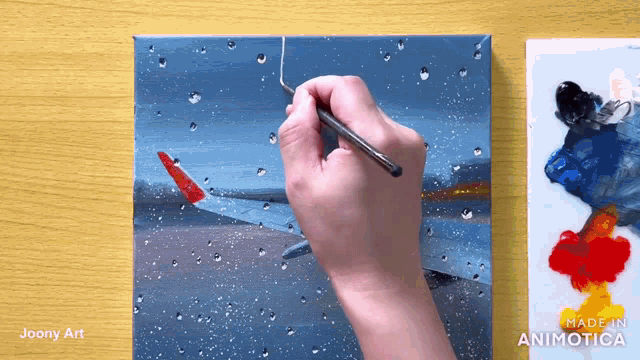 a person is painting an airplane on a canvas with a made in animatica logo in the corner