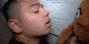 a man is kissing a stuffed animal in front of an employment application form .