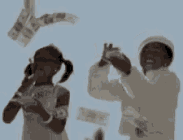 a man and a girl are throwing money into the air .