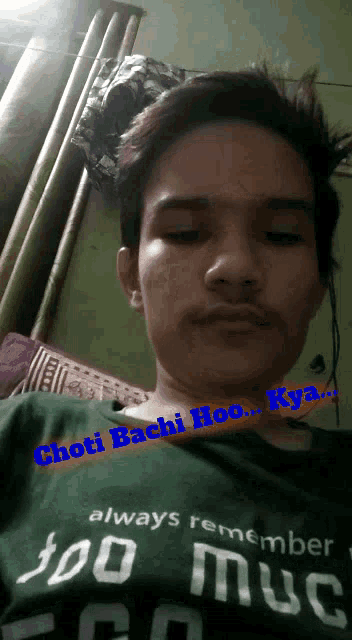 a young man is wearing a green shirt that says ' chou bachi hoo kya ' on it