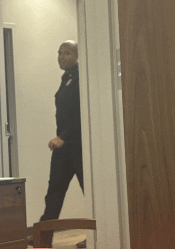a reflection of a man in a doorway with a chair in the foreground