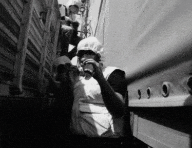 a black and white photo of a woman drinking water from a cup