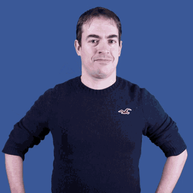 a man wearing a hollister sweater is covering his eyes