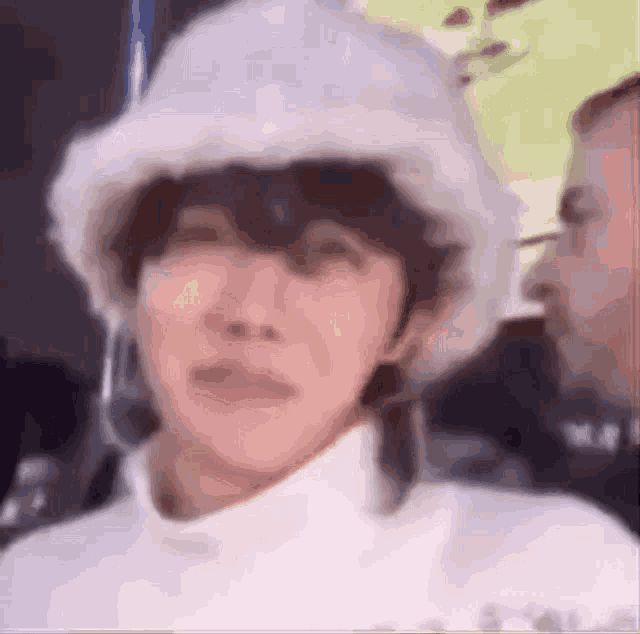 a close up of a person wearing a white hat and a turtleneck .