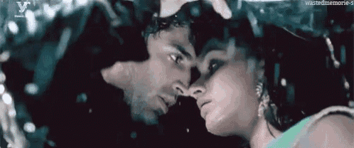 a man and a woman are kissing in the rain