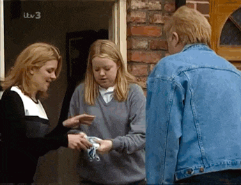 a group of people are standing in front of a brick building with a sign that says ' itv 3 ' on it