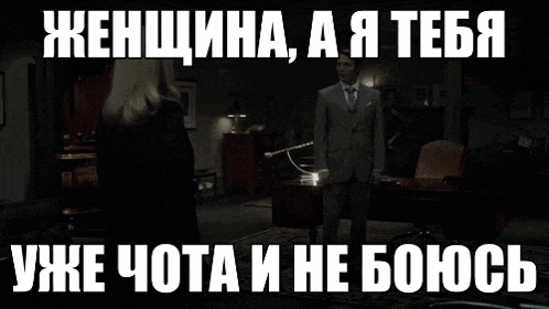 a woman in a black dress is standing in front of a window in a room with a caption in russian .