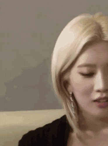 a close up of a woman 's face with blonde hair and earrings