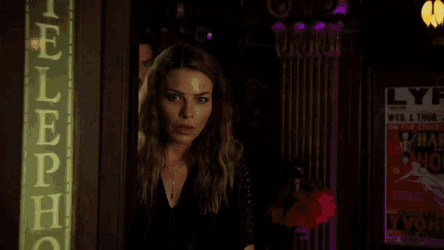a man in a white suit stands next to a woman in a dark room