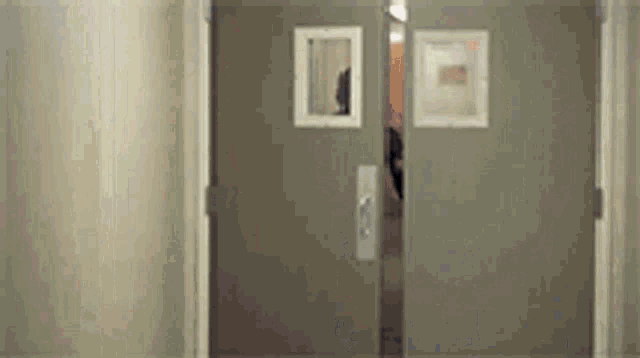 a person is walking through a hallway with two doors open