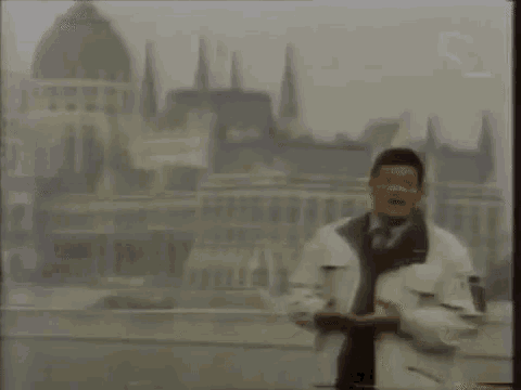 a car is driving down a street in front of a building with a dome