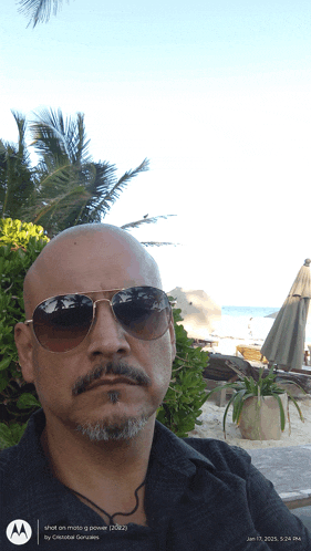 a man wearing sunglasses takes a selfie on a moto g power
