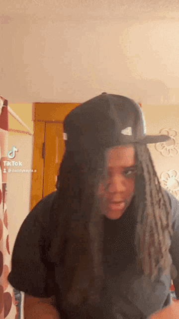 a woman wearing a black hat and a blue shirt has tiktok written on the bottom right corner